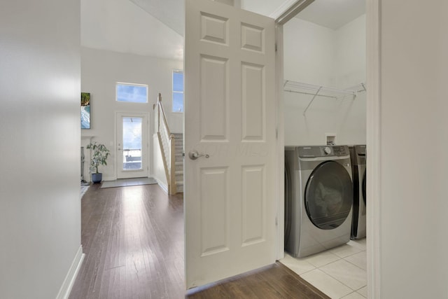 laundry area featuring baseboards, washer / clothes dryer, light wood-style flooring, and laundry area