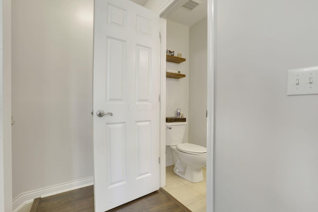 bathroom featuring visible vents, toilet, baseboards, and wood finished floors