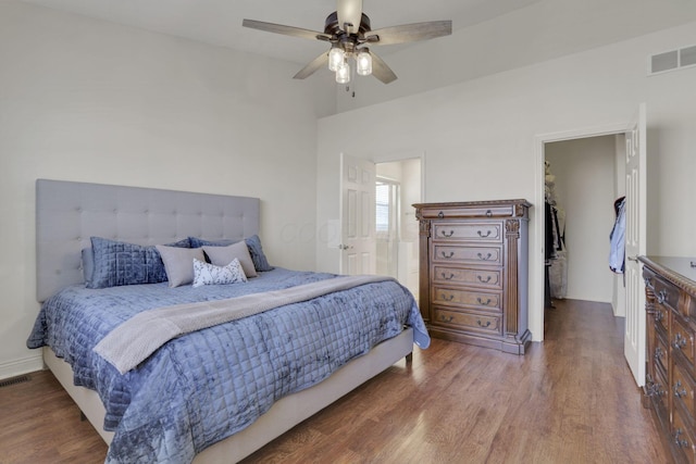 bedroom featuring a ceiling fan, wood finished floors, visible vents, and baseboards