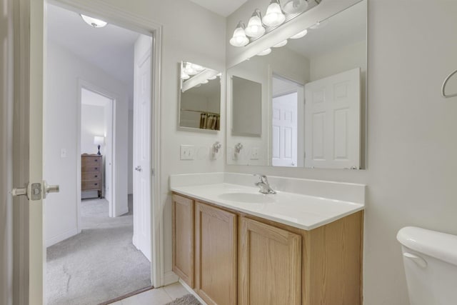 bathroom featuring vanity, toilet, and baseboards