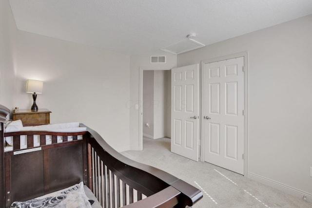 carpeted bedroom with visible vents, attic access, and baseboards