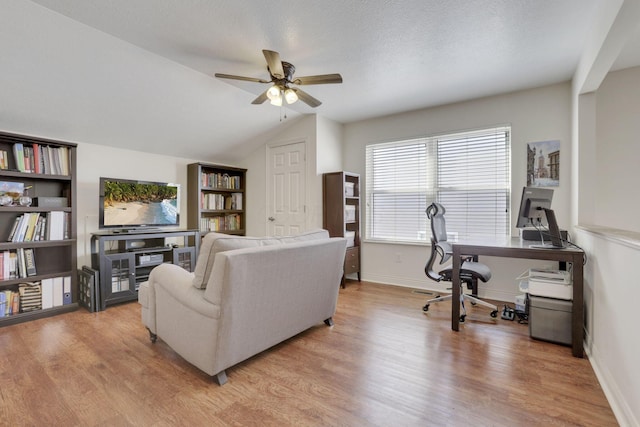 living room featuring vaulted ceiling, a ceiling fan, baseboards, and light wood finished floors