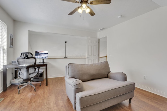 living area featuring wood finished floors, visible vents, and baseboards