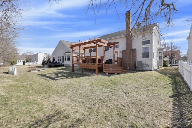 back of property with a wooden deck, a lawn, a pergola, and fence