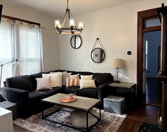 living room with dark wood finished floors and an inviting chandelier