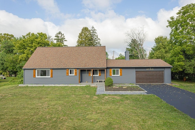 view of front of house featuring driveway, an attached garage, a front lawn, and roof with shingles