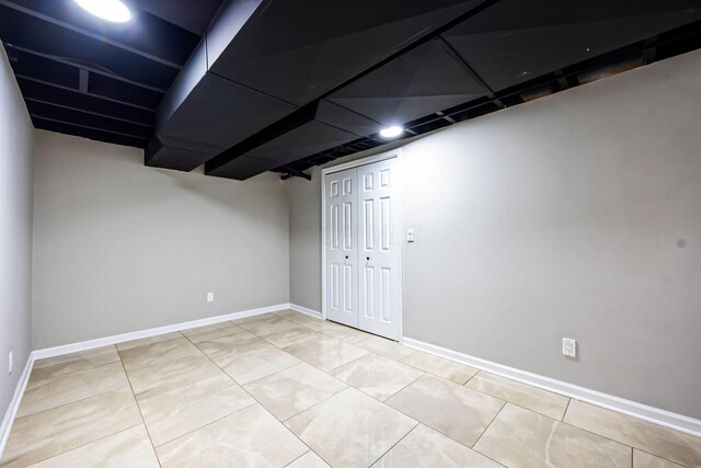 finished basement with baseboards and tile patterned flooring