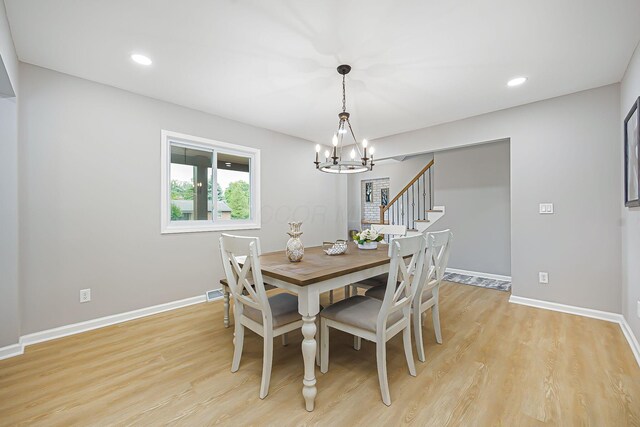 dining area featuring light wood-style flooring, recessed lighting, baseboards, a chandelier, and stairs