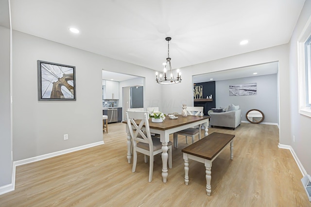 dining room with an inviting chandelier, light wood-style flooring, recessed lighting, and baseboards