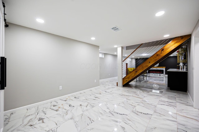 finished basement featuring stairway, recessed lighting, visible vents, and baseboards