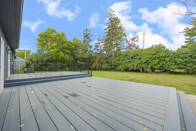 wooden terrace featuring a yard and fence