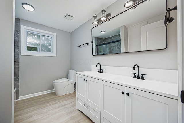 bathroom featuring a sink, visible vents, toilet, and walk in shower