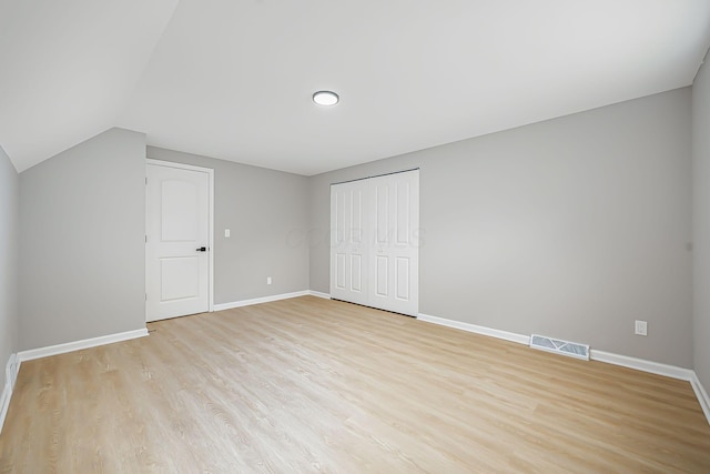 unfurnished bedroom with light wood-style flooring, baseboards, visible vents, and a closet