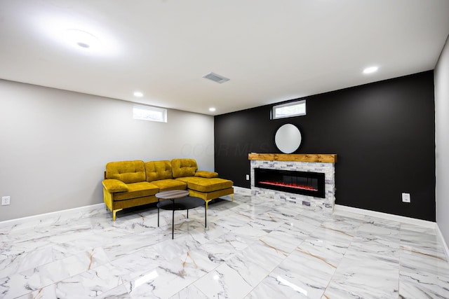 living area featuring visible vents, marble finish floor, a glass covered fireplace, recessed lighting, and baseboards