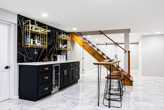 bar featuring indoor wet bar, stairs, recessed lighting, and marble finish floor