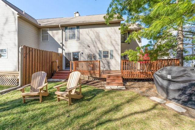 rear view of property with a yard, fence, and a wooden deck