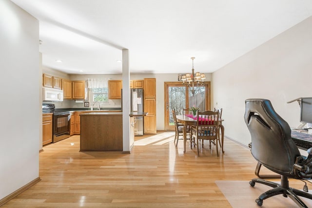 interior space with light wood-style flooring, a notable chandelier, and baseboards