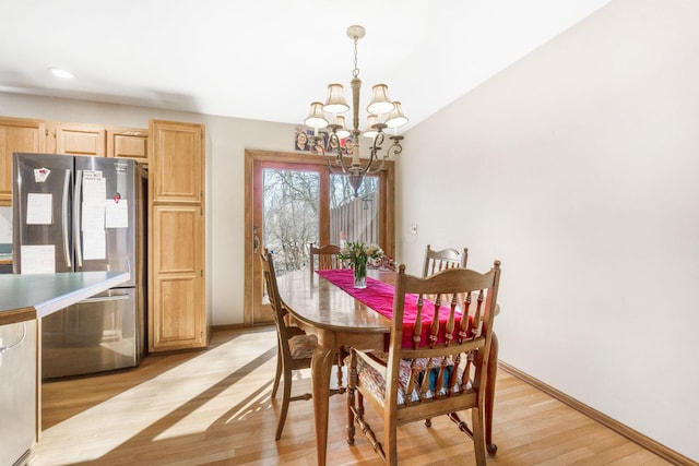 dining area with recessed lighting, baseboards, an inviting chandelier, and light wood finished floors