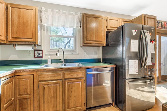 kitchen with a sink, appliances with stainless steel finishes, and brown cabinetry