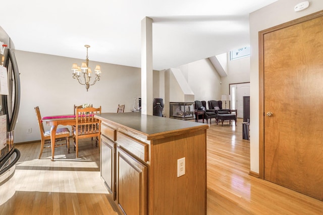 kitchen featuring dark countertops, light wood-type flooring, and freestanding refrigerator