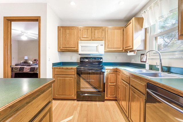 kitchen with white microwave, stainless steel dishwasher, light wood-style floors, electric range, and a sink