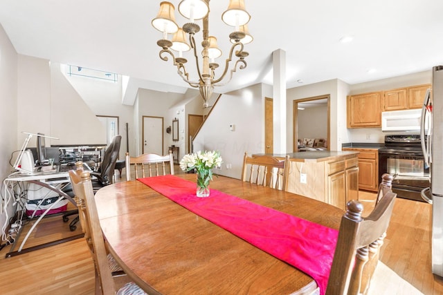 dining space with a notable chandelier, recessed lighting, and light wood-style floors