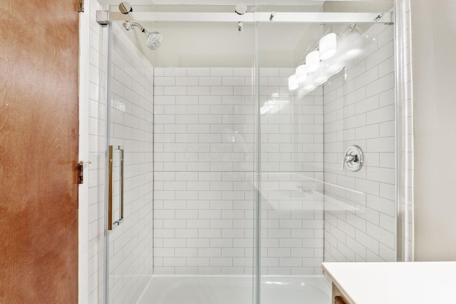 full bathroom featuring a tile shower and vanity