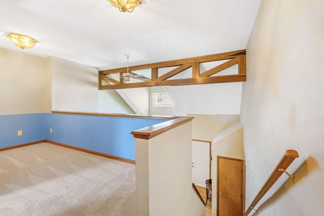 interior space with vaulted ceiling, a ceiling fan, baseboards, and carpet floors