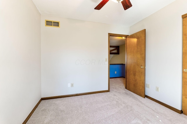 carpeted empty room with a ceiling fan, visible vents, and baseboards