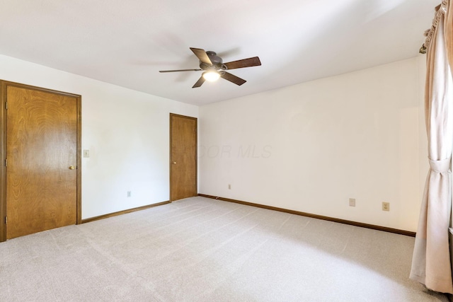 unfurnished bedroom with light colored carpet, baseboards, and ceiling fan