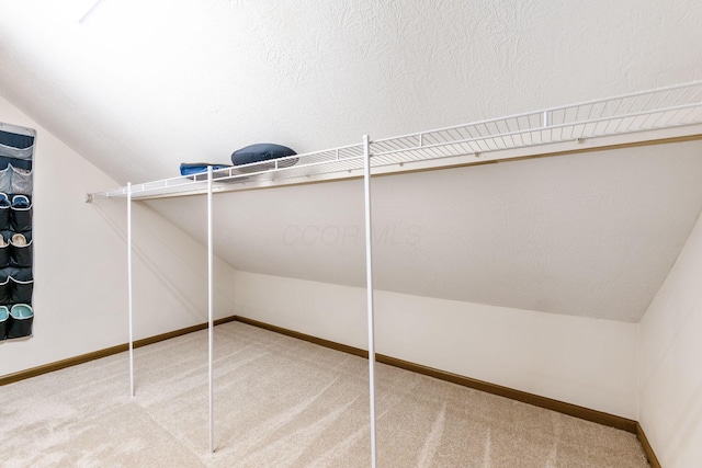 spacious closet featuring carpet and vaulted ceiling