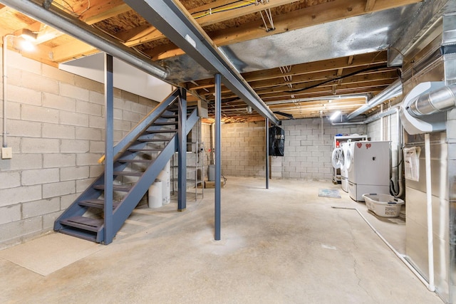 unfinished below grade area featuring stairway and independent washer and dryer