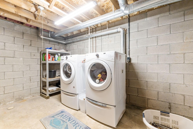 laundry area featuring washer and dryer, concrete block wall, and laundry area