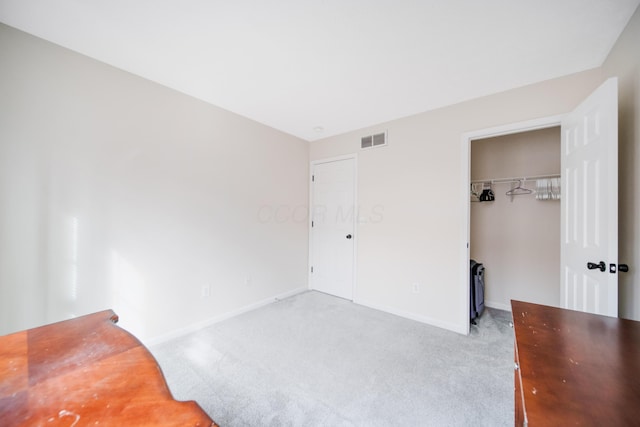 carpeted bedroom with visible vents, baseboards, a closet, and a spacious closet