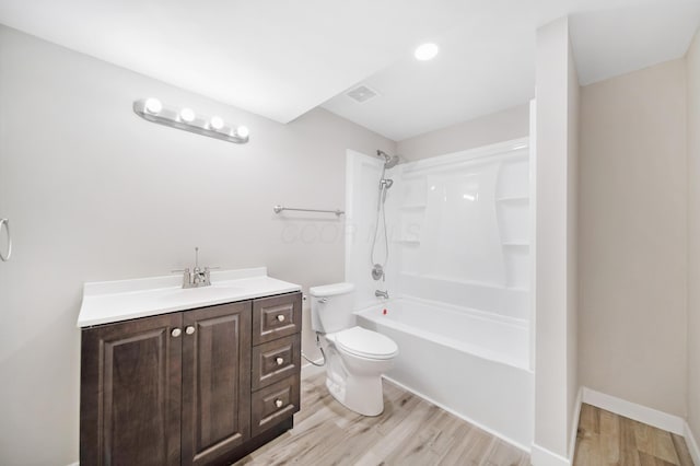 bathroom featuring visible vents, toilet, wood finished floors, vanity, and  shower combination