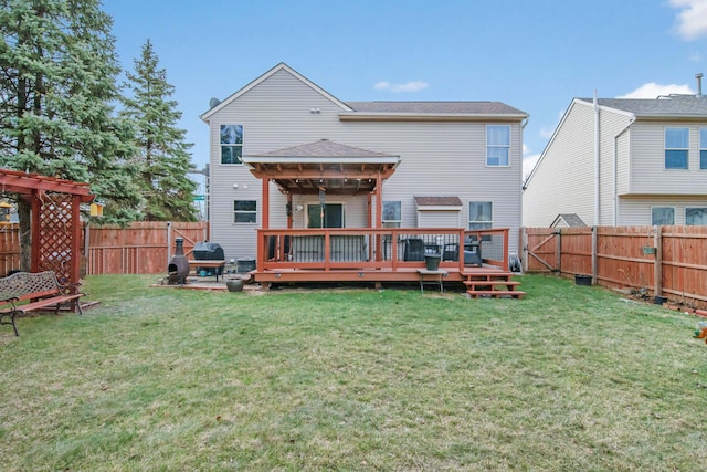 back of house featuring a wooden deck, a lawn, and a fenced backyard