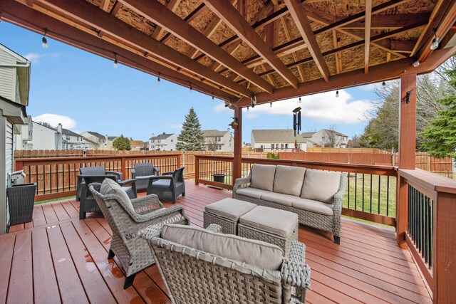 wooden terrace featuring outdoor lounge area, fence, and a residential view