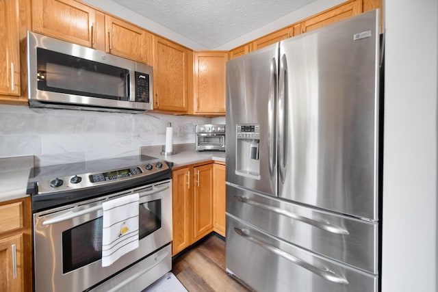 kitchen with light countertops, tasteful backsplash, appliances with stainless steel finishes, and a textured ceiling