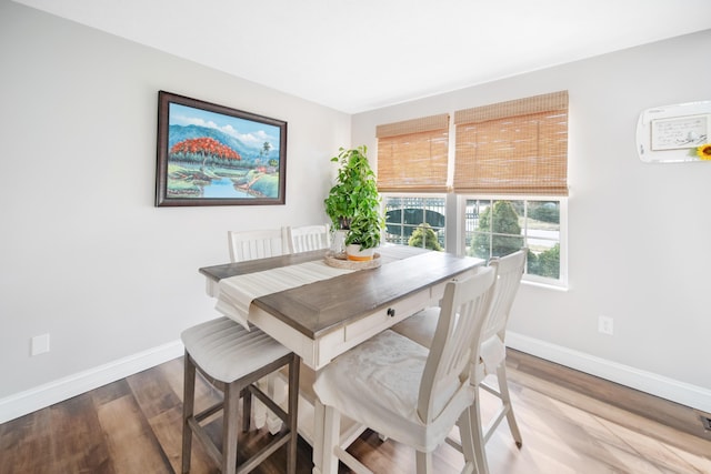 dining space featuring baseboards and wood finished floors