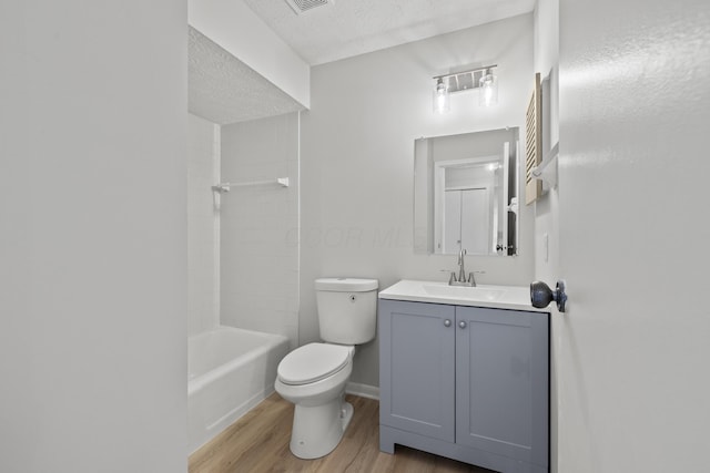 full bath featuring toilet, a textured ceiling, wood finished floors, baseboards, and vanity