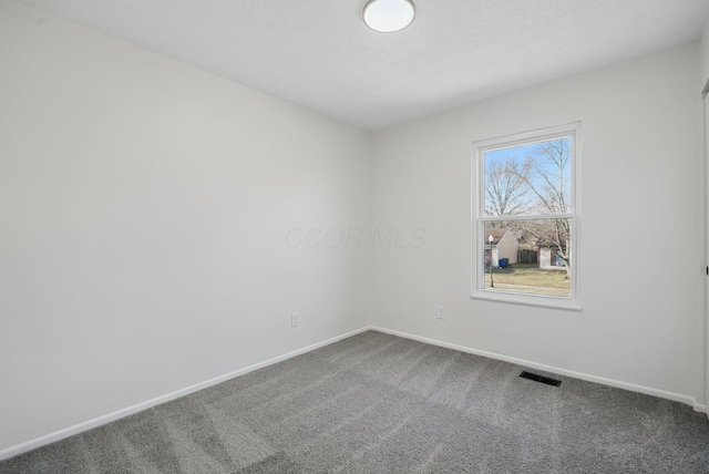 unfurnished room with visible vents, baseboards, and carpet flooring