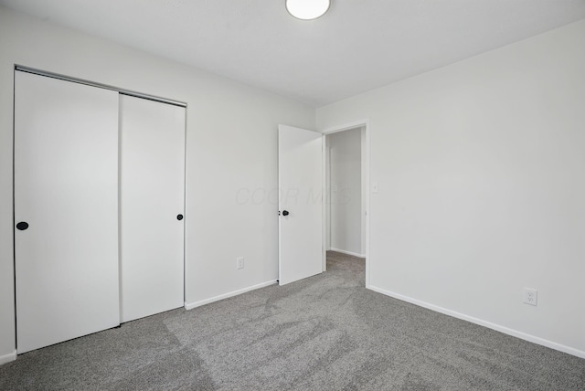 unfurnished bedroom with baseboards, a closet, and carpet floors