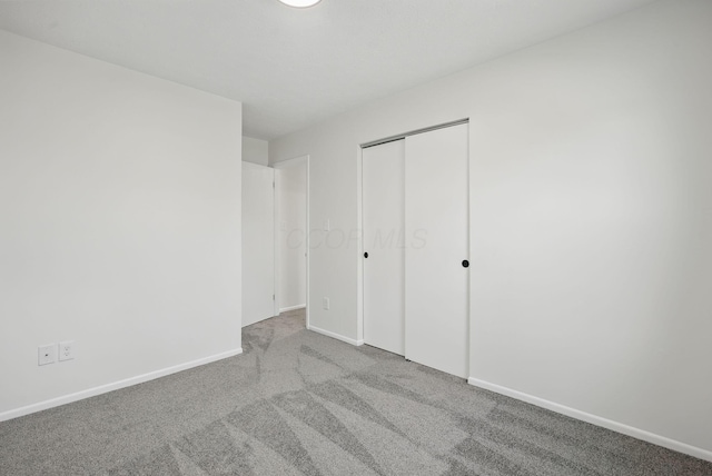 unfurnished bedroom featuring baseboards, a closet, and carpet floors