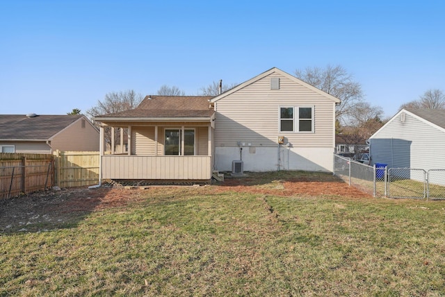 back of house featuring a yard, a fenced backyard, and a gate