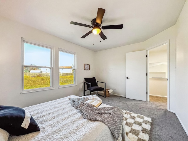 carpeted bedroom with ceiling fan and baseboards