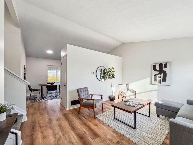 living area featuring lofted ceiling, stairway, wood finished floors, and baseboards