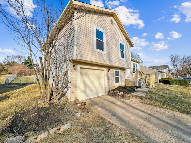 view of property exterior featuring a yard, driveway, a garage, and fence