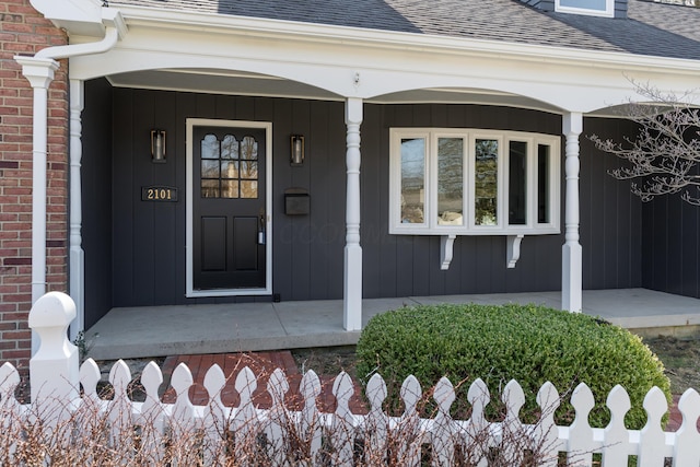 property entrance with covered porch and roof with shingles