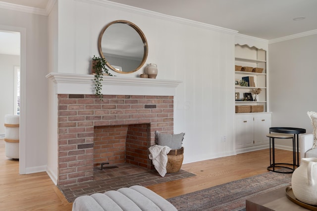 living area with a brick fireplace, wood finished floors, baseboards, and ornamental molding