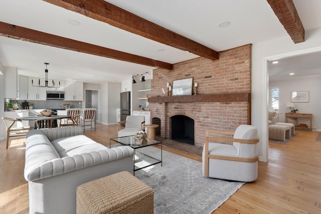 living area with beamed ceiling, light wood-type flooring, and baseboards